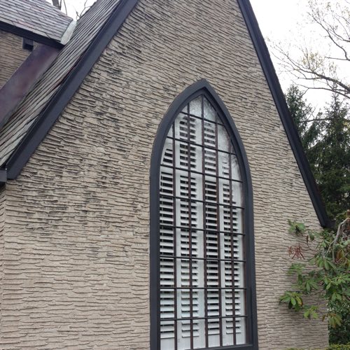 Exterior face of stone home with plantation shutters